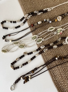 Nahaufnahme verschiedener Boho-Taillenketten mit Muscheln und Holzperlen für Kleider.