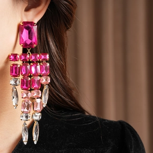 Detailed view of luxury vintage pink rhinestone tassel earrings on a model's ear