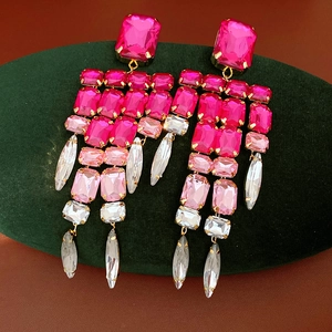 Macro view of vintage-style square tassel earrings featuring vibrant pink crystals.