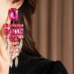 Close-up of pink and clear square rhinestone tassel earrings with multi-layer design.