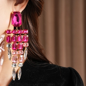 Close-up of fuchsia and pink rhinestone tassel earrings with vintage luxury aesthetic