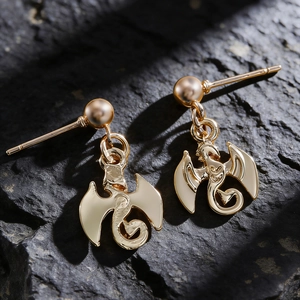 Vue détaillée de boucles d'oreilles dragon en or sur une surface en pierre naturelle