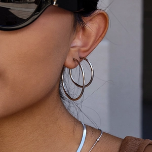 Détail de boucles d'oreilles créoles minimalistes en acier inoxydable argenté