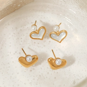 Eleganti orecchini a cuore dorati con perle su un bellissimo sfondo di vetro strutturato