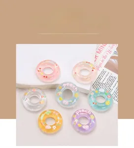 Close-up of translucent colorful resin donut charms with cute cartoon patterns for DIY