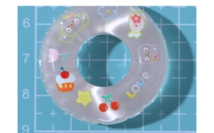 Macro shot of DIY resin ring charm with colorful cartoon bear and cherry patterns