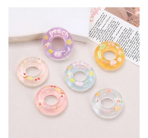Close-up of colorful DIY resin charms in lifebuoy shapes with various fruit patterns