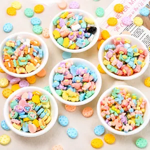 Macro view of assorted macaron-colored resin charms in bowls for DIY craft making