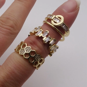 Set di anelli a nido d'ape dorati con micro pavé di zirconi e dettagli geometrici