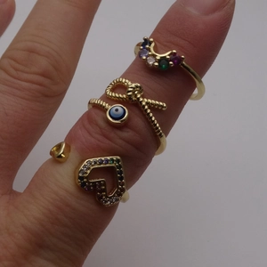 Set di tre anelli regolabili in oro con zirconi multicolore e ciondoli a cuore e occhio