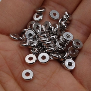 Primer plano de espaciadores de plata pulida en mano para creación de joyas caseras