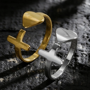 Detailaufnahme von minimalistischen Herz- und Kreuzringen aus Edelstahl in Gold und Silber