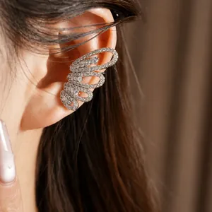 Elegant silver-toned zircon-encrusted butterfly ear cuff worn on model's ear cartilage.