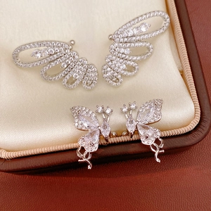 Close-up detail of sparkling butterfly and wing earrings set with clear cubic zirconia stones