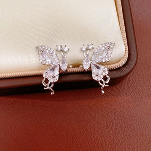 Detailed macro view of shiny silver butterfly ear clips with cubic zirconia stone inlay