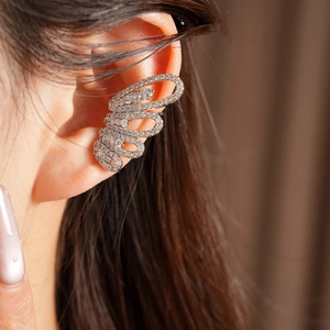 Detailed close-up of a sparkling cubic zirconia butterfly ear cuff on a real ear