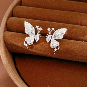 Detailed view of sparkling zircon-inlaid butterfly ear cuffs on velvet