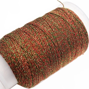 Detalle de cordón trenzado metálico rojo verde oro en carrete para joyería artesanal