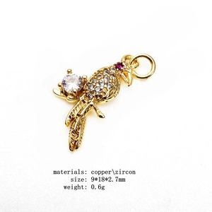 Macro view of gold parrot charm with micro-set zircons for bracelets and necklaces