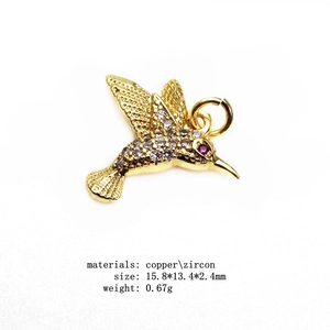 Detailed view of hummingbird pendant with white zircon micro-pave and a red eye accent