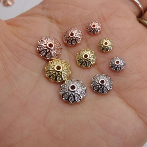 Distanziatori a fiore in zircone scintillante in oro, argento e oro rosa sulla mano