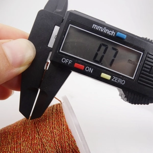 Primer plano de hilo trenzado metálico rojo y dorado de 0,7 mm medido con un pie de rey