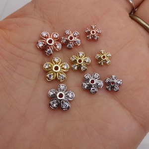 Distanziatori a fiore con zirconi micro-pavé in oro e argento su palmo per scala