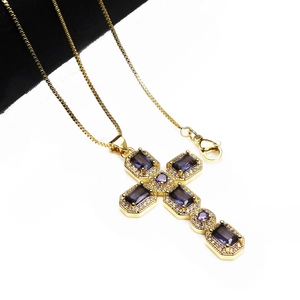 Close-up of gold cross necklace with purple zircon stones and sparkling diamond accents