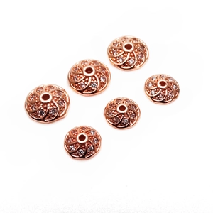 Vista macro di distanziali a vortice oro rosa con micro-zirconi per gioielli fai-da-te