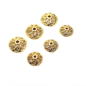 Vista macro di 6 perline a spirale placcate in oro con zirconi micro-pave per gioielli DIY