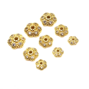 Dettaglio di distanziatori a fiore dorati con zirconi per braccialetti fai-da-te