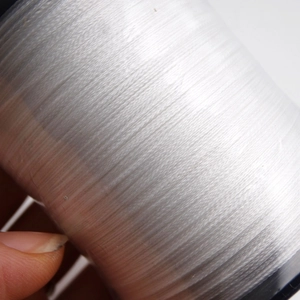 Macro shot of high-quality white silk pearl thread wound neatly on a spool for DIY jewelry