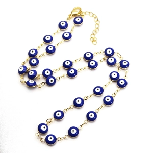 Detail einer verstellbaren vergoldeten Halskette mit blau-weißen Evil-Eye-Anhängern
