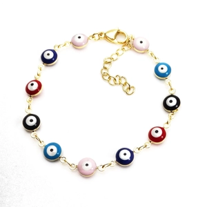 Detail eines Goldarmbands mit bunten Emaille-Evil-Eye-Perlen und Karabinerverschluss
