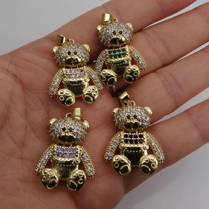 Goldene Bärenanhänger mit bunten Zirkoniasteinen auf Handfläche für Modeschmuck