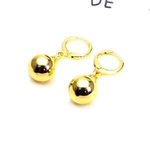 Detailed macro view of 18K gold plated polished spherical drop earrings on white