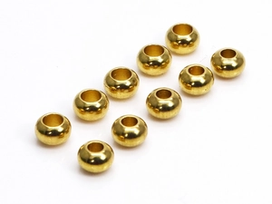 Vista macro de 10 cuentas de latón dorado pulido para la creación de joyas artesanales