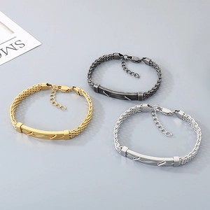 Détail de bracelets tressés en acier inoxydable pour hommes en or, argent et noir.