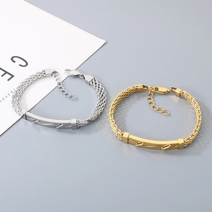 Détail de bracelets tissés en acier inoxydable doré et argenté avec plaque à clous.