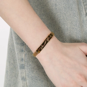 Détail macro d'un bracelet pour homme en acier inoxydable doré tressé de style professionnel