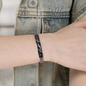 Gros plan d'un bracelet tressé en acier inoxydable pour homme avec design noir