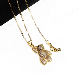 Dettaglio macro della collana con ciondolo a orso dorato e cristalli micro-pave