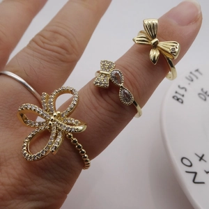 Dreiteiliges vergoldetes Schleifen-Ring-Set mit Zirkonia-Mikropflaster auf der Hand