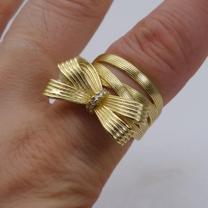 Detailaufnahme des 14k Gold-Schleifenrings mit Zirkonia-Besatz und gebürsteter Textur