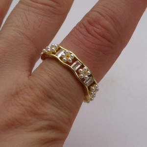 Dettaglio dell'anello placcato oro 14k con zirconi e perle sulla mano di una modella