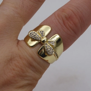 Nahaufnahme des 14k vergoldeten Schleifenrings mit Zirkonia-Mikropavé an der Hand