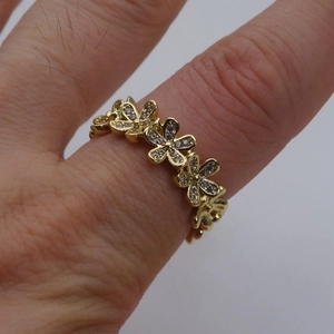 Dettaglio dell'anello regolabile placcato oro 14k con fiori di zirconi incastonati