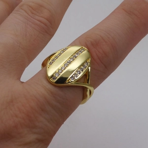 Nahaufnahme eines goldenen Rings mit Zirkonia-Mikropavé und geteilter Ringschiene im Detail