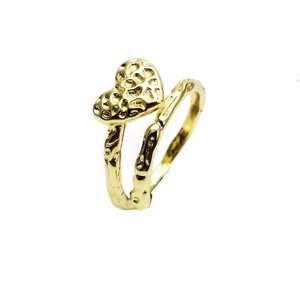Dettaglio dell'anello aperto dorato a forma di cuore con finitura martellata fatta a mano
