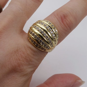 Macro detail of wide dome 14k gold plated ring featuring micro-paved cubic zirconia layers
